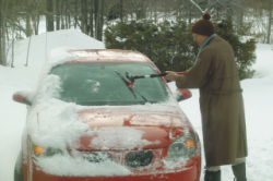 Brushing the snow of the car.