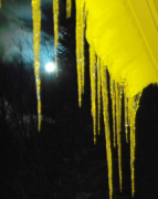 the moon looking in between icicles